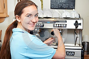 Woman In Cafe Making Cup Of Coffee