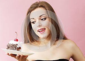 Woman with cake licking lips