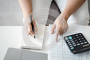Woman is calculating annual tax with calculator and filling form of Individual Income Tax Return. Season to pay Tax and Budget