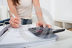 Woman calculating home finances at table