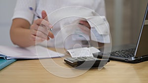 woman calculating monthly home expenses, tax, bank account balance and credit card bills payment. Woman with bills and