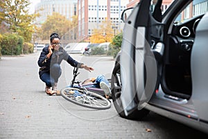 Woman Calling For Help Near Unconscious Cyclist Lying On Street