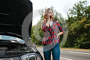 Woman calling a tow truck on road, car breakdown