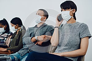 Woman calling while traveling with covid and waiting in line at airport while wearing a mask for protection. For hygiene