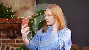 Woman calls by video link near the Christmas tree. congratulates friends