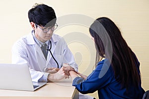 The woman came to see the doctor. The doctor measures the pulse of the patient