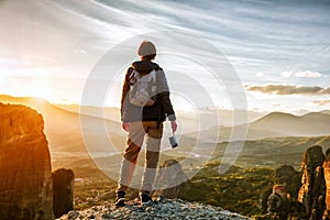 Woman with camera enjoying sunset on mountain