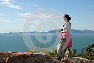 Woman with camera looking out to sea, Australia