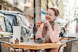 Woman with camera in outdoor cafe. Barcelona, Catalonia.