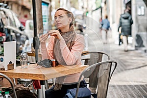 Woman with camera in outdoor cafe. Barcelona, Catalonia.