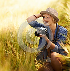 Woman, camera and photography with happy travel, vacation and holiday with wheat field and plants. Nature, photographer