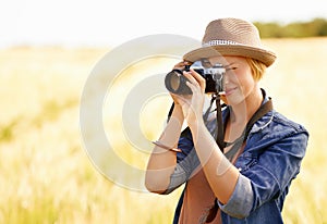 Woman, camera and photography with safari, vacation and holiday with wheat field and plants. Nature, photographer and