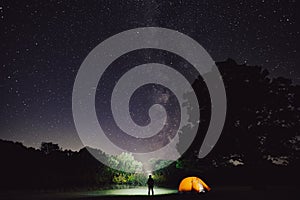 Una donna campeggio una tenda foresta di notte stellare il cielo 