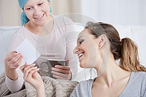 Woman with cancer and her friend looking at photograph