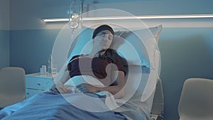 Woman with cancer sleeping in a hospital bed