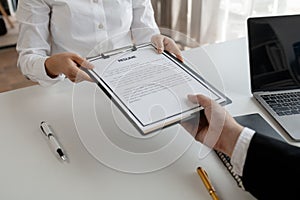 Woman candidate interview with HR manager in office, Examiner reading a resume during job interview at office Business and human