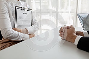 Woman candidate interview with HR manager in office, Examiner reading a resume during job interview at office Business and human