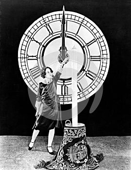 Woman with candle and clock on New Years Eve