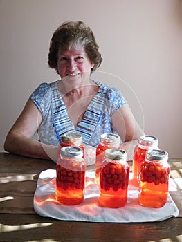 Woman with canned cherry fruit
