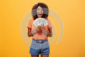 Woman cannot hide happiness winning lottery. Portrait of surprised and happy lucky african american young woman with