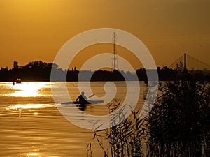 Woman canoeing at sunset on Vistula river, Poland. Amazing scenery and colors.