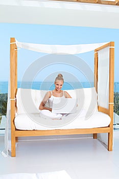 Woman on canopied seat with laptop