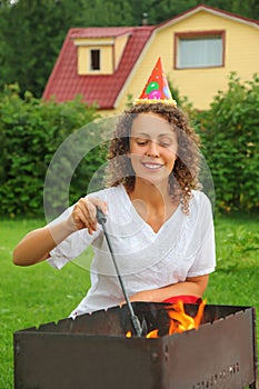Woman in cap near brazier, happy birthday photo