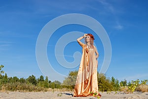 Woman in a cape of gold fabric. Fashion and Style