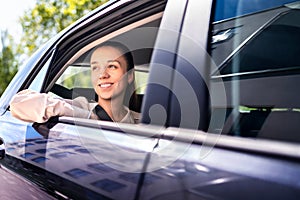 Woman in car as passenger on the backseat. Smiling female customer in taxi cab looking out the window. Happy elegant businesswoman