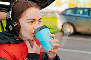 Woman in car, autumn concept. Smiling beautiful girl listening to music