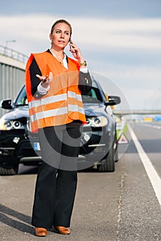 Woman with car breakdown calling towing company