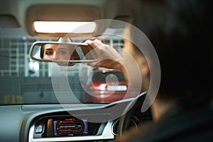 Woman, car and checking mirror in parking lot for observation, awareness or transportation. Female person or driver