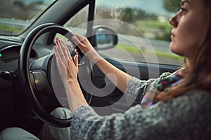 Woman, car and driving with honk on road for alert, emergency or traffic in travel, trip or transport. Female person photo