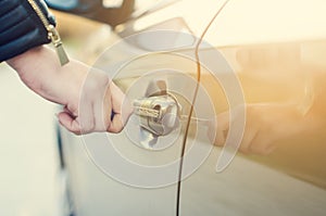 Woman with car key. Opening car door. WomanÃÂ´s hand unlocking a door on a car. Sunlight. Transportation.