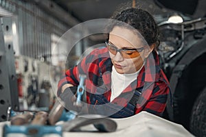 Woman car mechanic working in automobile garage