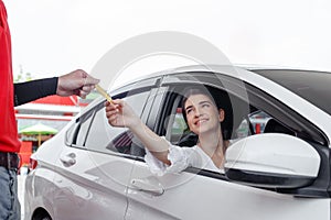 Woman in car paying credit card after refuel car â€‹spending instead of cash with man service employee at gas station.