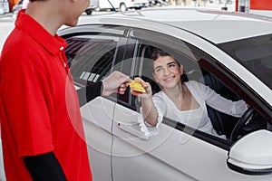 Woman in car paying credit card after refuel car â€‹spending instead of cash with man service employee at gas station.