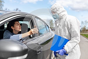 Woman in car showing phohe to healthcare worker