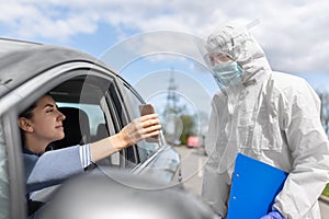 Woman in car showing phohe to healthcare worker