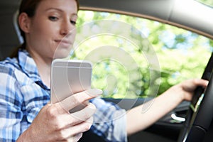 Woman In Car Texting On Mobile Phone Whilst Driving photo