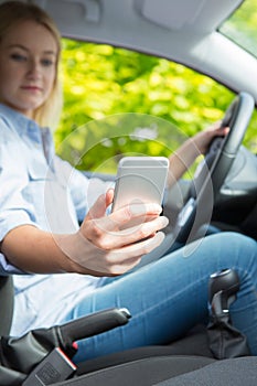 Woman In Car Texting On Mobile Phone Whilst Driving