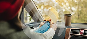 Woman in a car in warm woolen yellow socks on the car dashboard. Cozy autumn weekend trip. Concept of freedom of travel