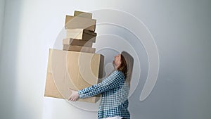 Woman with cardboard boxes, delivery girl holds and drops things. Falling storage