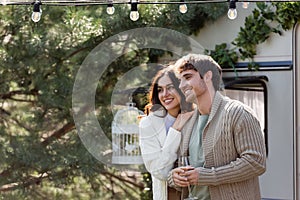 Woman in cardigan hugging boyfriend with