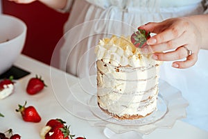 Woman Carefully Icing The Cake