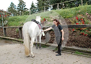 A woman caring for a horse.