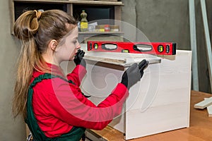 Woman carpenter measure wooden plank in workshop