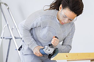 Woman carpenter using angle grinder