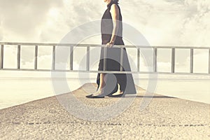 Woman carries a long ladder to climb into the sky