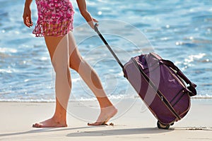 Woman carries your luggage near the blue ocean